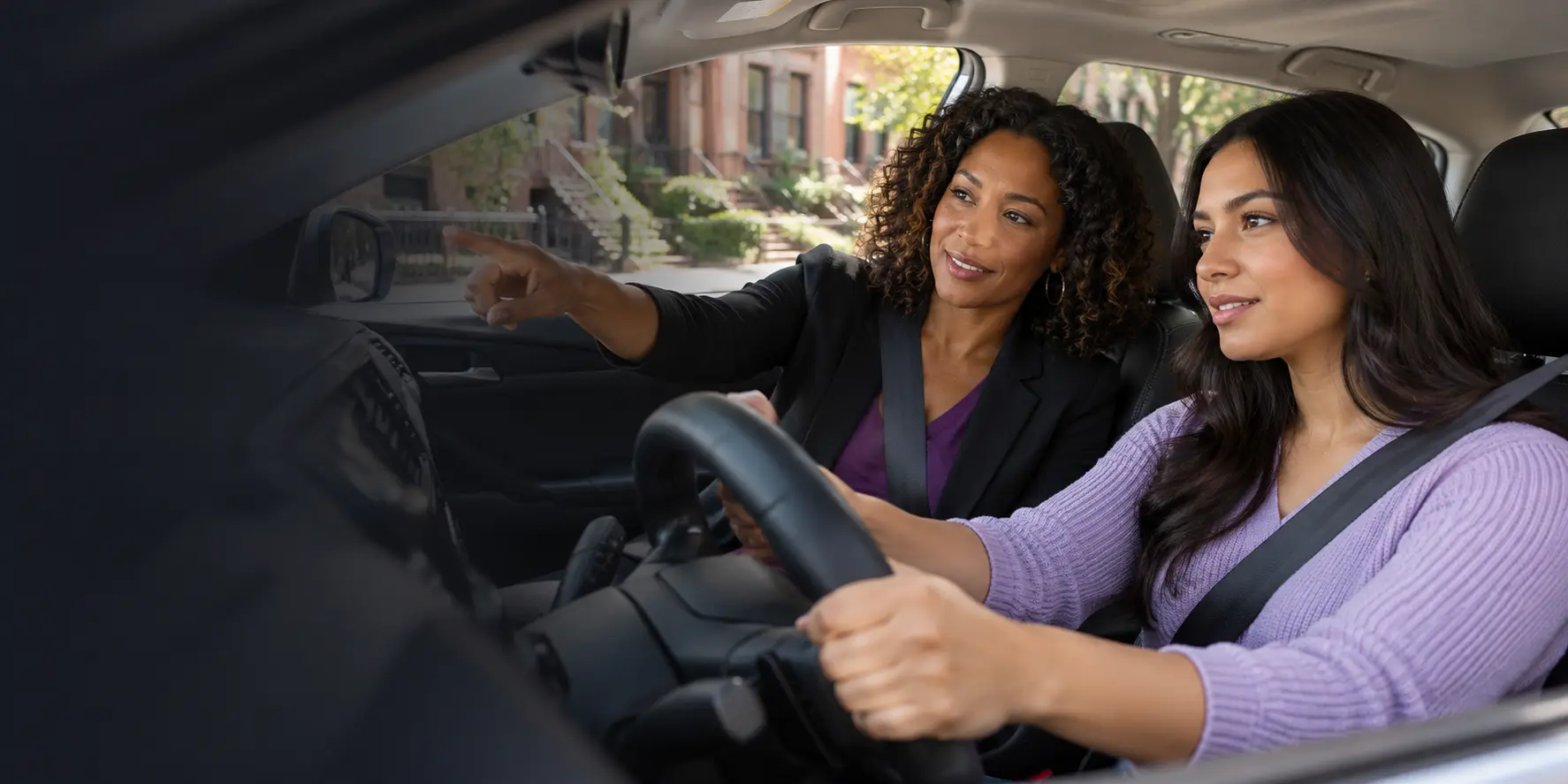 Professional female driving instructor teaching an adult student in Brooklyn